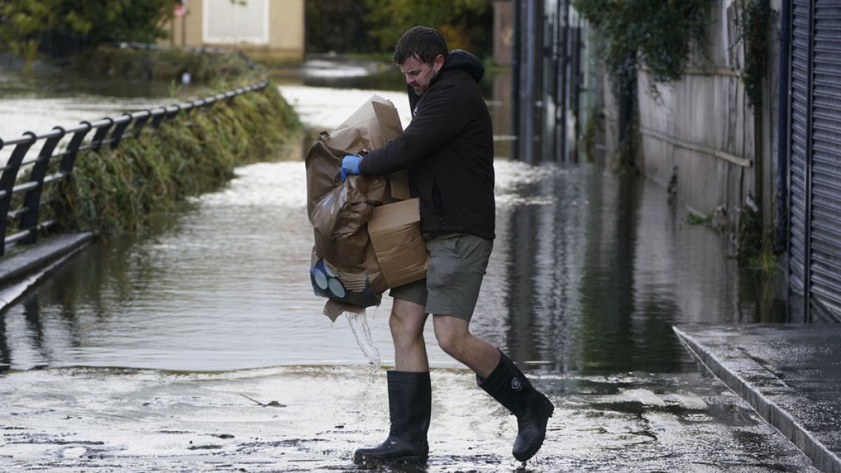 In Newry, Nordirland, räumt ein Mann nach heftigen Regenfällen sein Geschäft
