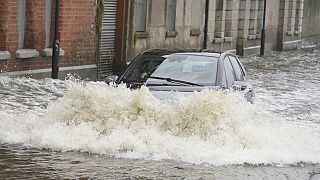 A car drives through flood water on Canal Quay in Newry Town, Co Down, which has been swamped by floodwater as the city's canal burst its banks amid heavy rainfall.