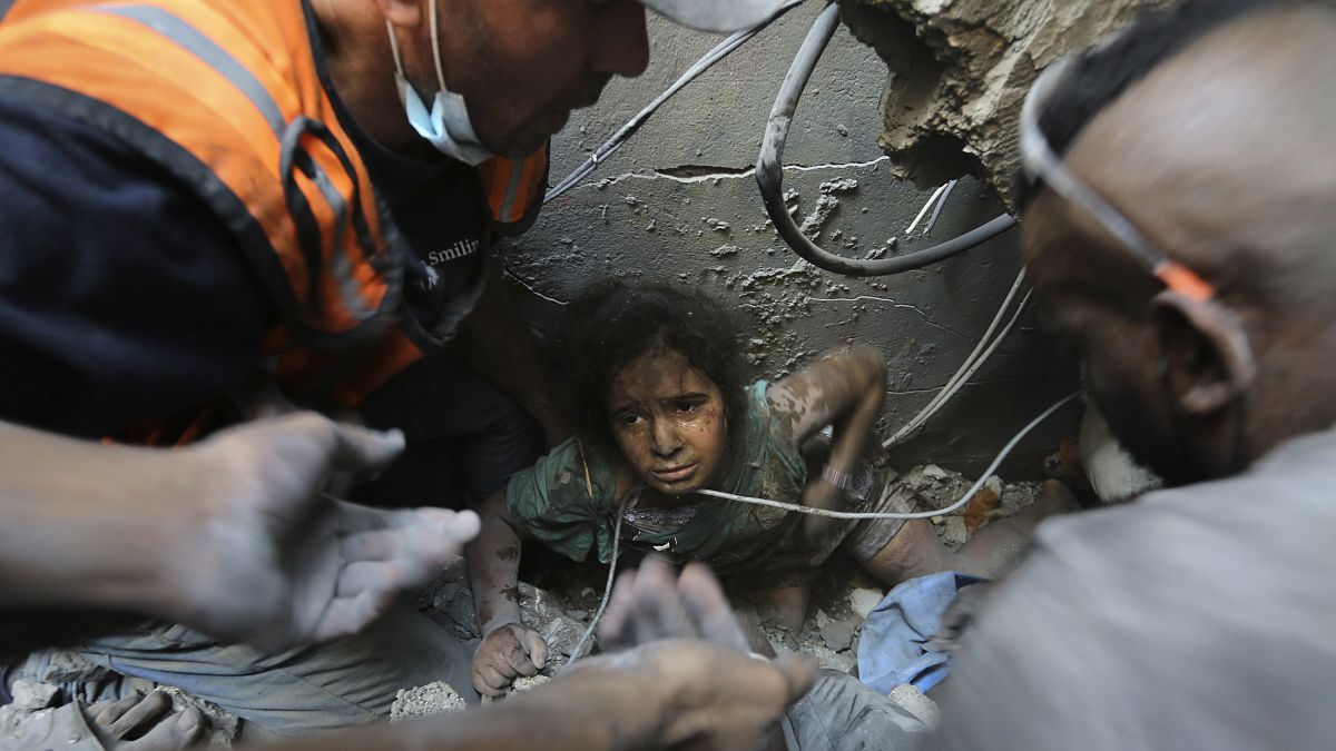 فلسطينيون يحاولون انتشال فتاة من تحت أنقاض مبنى دمرته الغارات الجوية الإسرائيلية في مخيم جباليا للاجئين