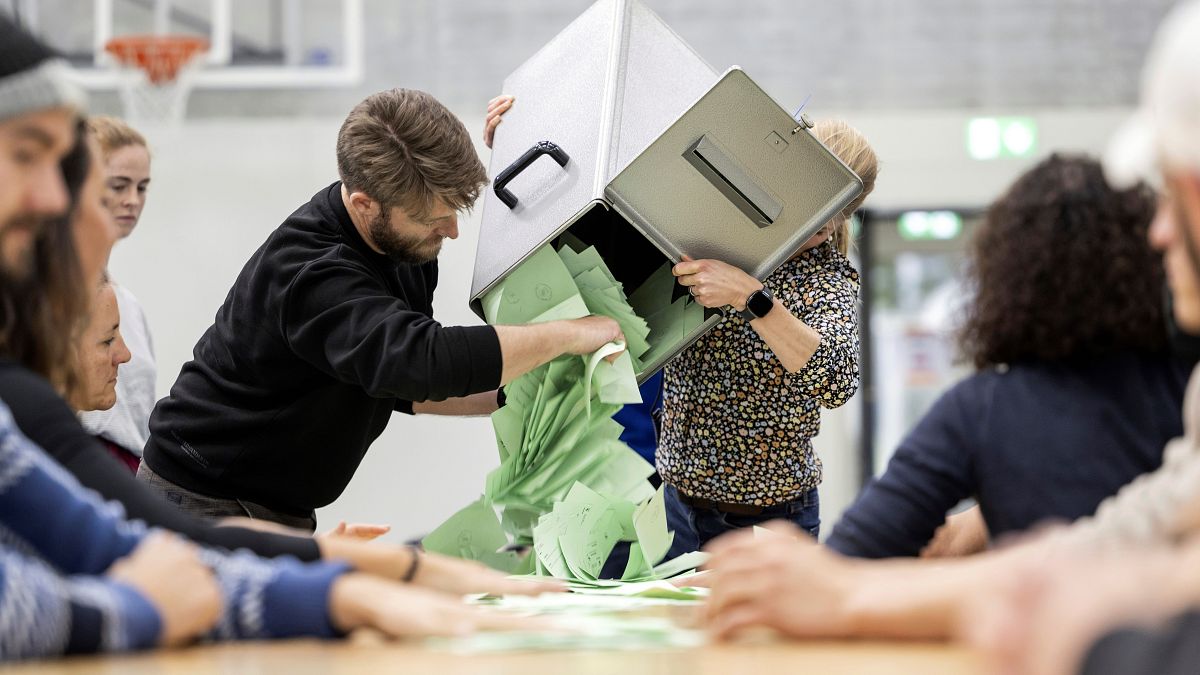 يقوم موظفو فرز الأصوات بإفراغ صندوق الاقتراع لبدء فرز الأصوات في مركز الاقتراع في سويسرا 
