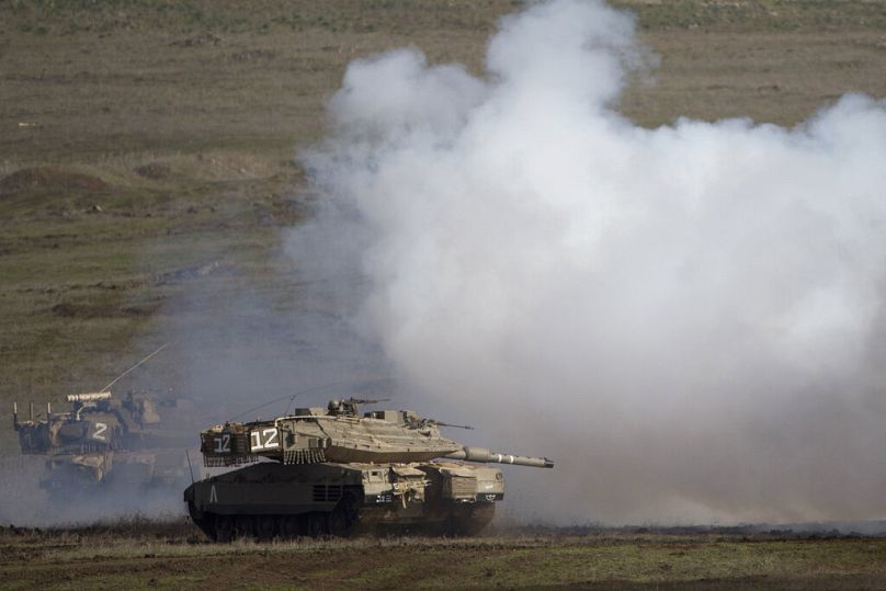 FILE - Israeli Merkava Mark 4 tanks drive during an exercise in the Israeli controlled Golan Heights, near the border with Syria, Monday, Jan. 11, 2016.