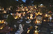 People gather in the section of children's tombs inside the San Gregorio Atlapulco cemetery during Day of the Dead festivities on the outskirts of Mexico City, early Wednesday