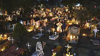 People gather in the section of children's tombs inside the San Gregorio Atlapulco cemetery during Day of the Dead festivities on the outskirts of Mexico City, early Wednesday
