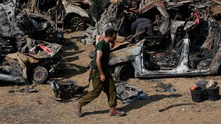 جندي إسرائيلي يفحص المركبات التي احترقت في هجوم 7 تشرين الأول / أكتوبر الذي شنته حماس على إسرائيل