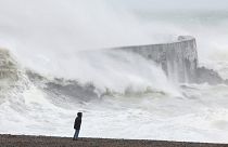 Une personne se tient sur la plage, tandis qu'une vague s'écrase sur le mur du port de Newhaven, alors que la tempête Ciaran frappe la côte anglaise, à Newhaven, en Grande-Bretagne.