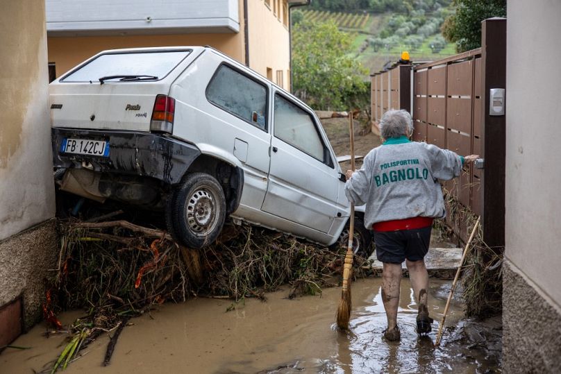 A woman tries to clean the mud in Montemurlo near Prato after heavy rain last night, on 3 November 2023. Storm Ciaran hit Tuscany late on 2 November 2023.