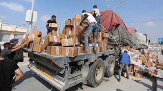 فلسطينيون ينهبون شاحنة معونات انقلبت حمولتها بالقرب من معبر رفح الحدودي بين قطاع غزة ومصر
