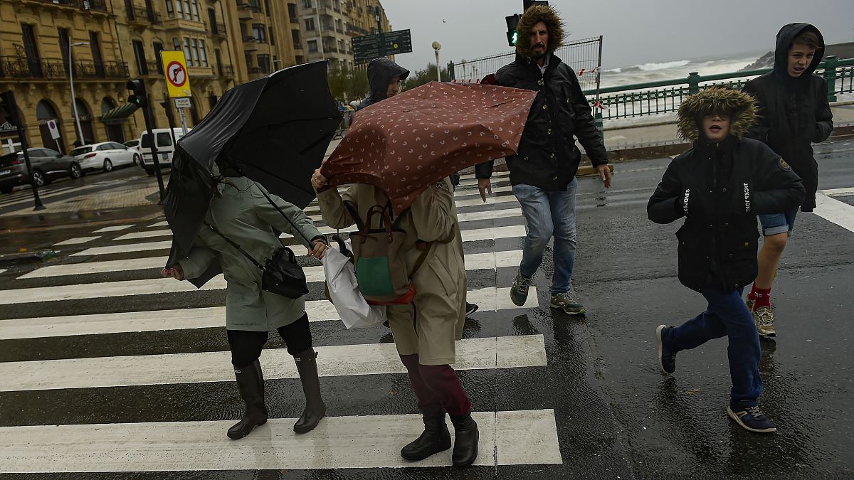 إسبانيون يحتمون من المطر في سان سيباستيان، شمال إسبانيا. 