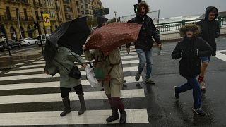 إسبانيون يحتمون من المطر في سان سيباستيان، شمال إسبانيا. 