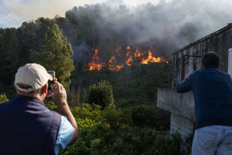 Villagers take photos as wildfire advances near the eastern town of Palma de Gandia in Valencia.