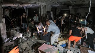 رجال الإنقاذ والناس يفتشون منزل الصحفي في تلفزيون فلسطين محمد أبو حطب
