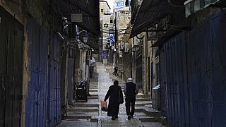 فلسطينيون يسيرون بجوار المتاجر المغلقة في البلدة القديمة بالقدس، الاثنين 16 أكتوبر 2023