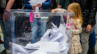 Une fille glisse un bulletin dans une urne lors des élections législatives en Pologne