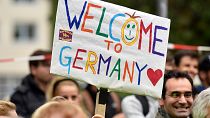 People welcome refugees with a banner reading 'welcome to Germany' in Dortmund, Germany, Sunday, Sept. 6, 2015.