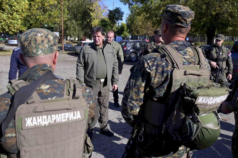 In this photo provided by the Serbian Interior Ministry, Serbian Interior Minister Bratislav Gasic speaks with police officers near the border between Serbia and Hungary.