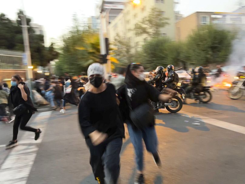 İran'da başında örtüsü bulunmayan kadınlar, Devrim Muhafızları Ordusu'na bağlı motosikletli Besiç güçleriyle çatışırken (2022)