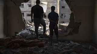 Palestinians look at the destruction after Israeli strikes on the Gaza Strip in Khan Younis on Saturday