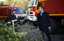 France's President Emmanuel Macron (R) speaks with a firefighter during a visit in a region hit by Storm Ciaran in Plougastel-Daoulas, western France