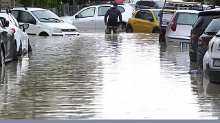 A man makes is way on a flooded street.