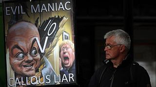 A „gonosz őrült” az „érzéketlen hazuggal” szemben – egy demonstráló Dominic Cummings és Boris Johnson karikatúrájával Londonban, 2023. október 31-én