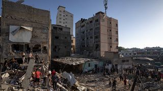Izraeli légicsapásban megsemmisült lakóház romjai között keresnek túlélőket palesztinok a Gázai övezet déli részén  2023. november 4-én. 
