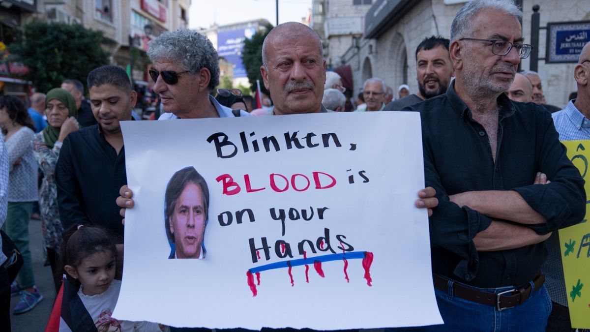 فلسطينيون يحملون ملصقات عليها صور وزير الخارجية الأمريكي أنتوني بلينكن خلال احتجاج على زيارته، في مدينة رام الله بالضفة الغربية، الأحد 5 نوفمبر 2023.