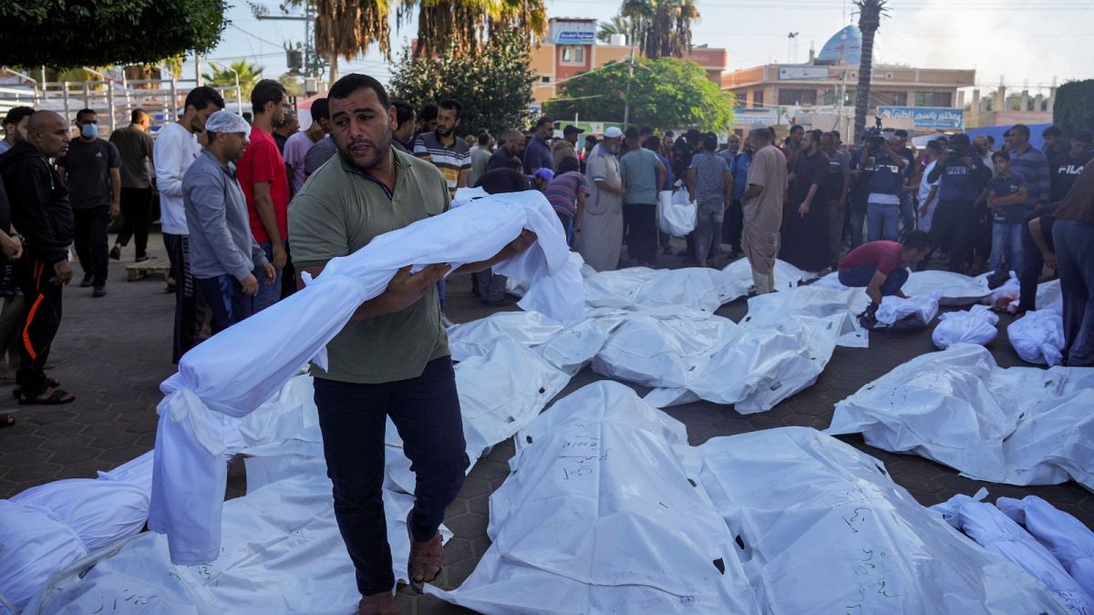 Palestinians mourn relatives killed in the Israeli bombardment of the Gaza Strip in front of the morgue in Deir al Balah, Monday, Nov. 6, 2023. 