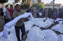 Palestinianos rezam junto aos corpos de familiares - Gaza