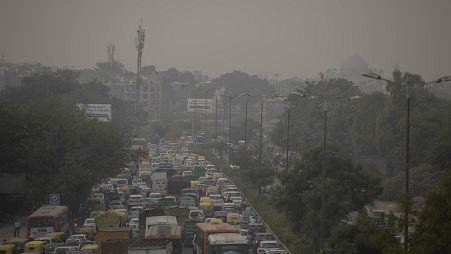 A pedestrian walks on a bridge above vehicle traffic in New Delhi, India
