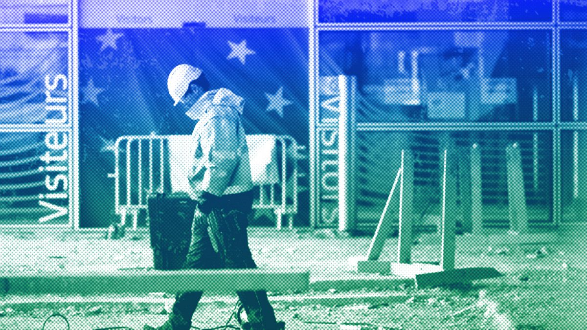 A construction worker stands in front of a door with the EU stars at EU headquarters in Brussels, October 2019