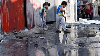 طفلان فلسطينيان يقومان بالتنظيف بعد قصف إسرائيلي على مخيم المغازي للاجئين في قطاع غزة يوم الأحد 5 نوفمبر 2023