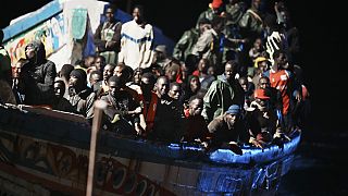 Μετανάστες συνωστίζονται σε μια ξύλινη βάρκα καθώς ρυμουλκούνται στο λιμάνι στη La Restinga στο νησί των Καναρίων Νήσων El Hierro το Σάββατο, 4 Νοεμβρίου 2023.