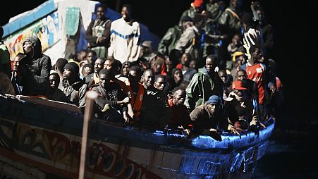 Migrants crowd a wooden boat as they are towed to the port in La Restinga on the Canary island of El Hierro on Saturday, Nov. 4, 2023. 