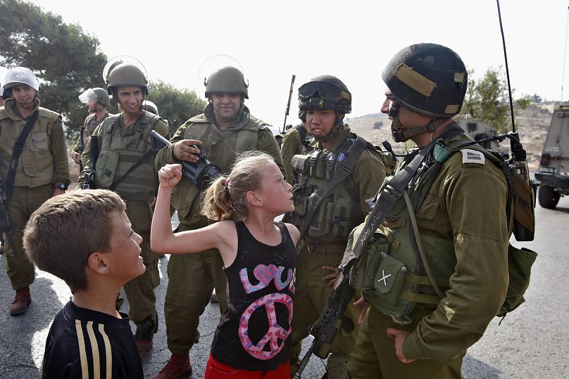 عهد التميمي عندما كانت طفلة عام 2012، تواجه جنودا إسرائيليين في قرية النبي صالح في الضفة الغربية المحتلة