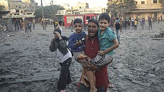 Palestinian walk away after Israeli airstrike in Rafah, Gaza Strip, Tuesday, Nov. 7, 2023. 