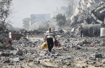 Местные жители на руинах в секторе Газа