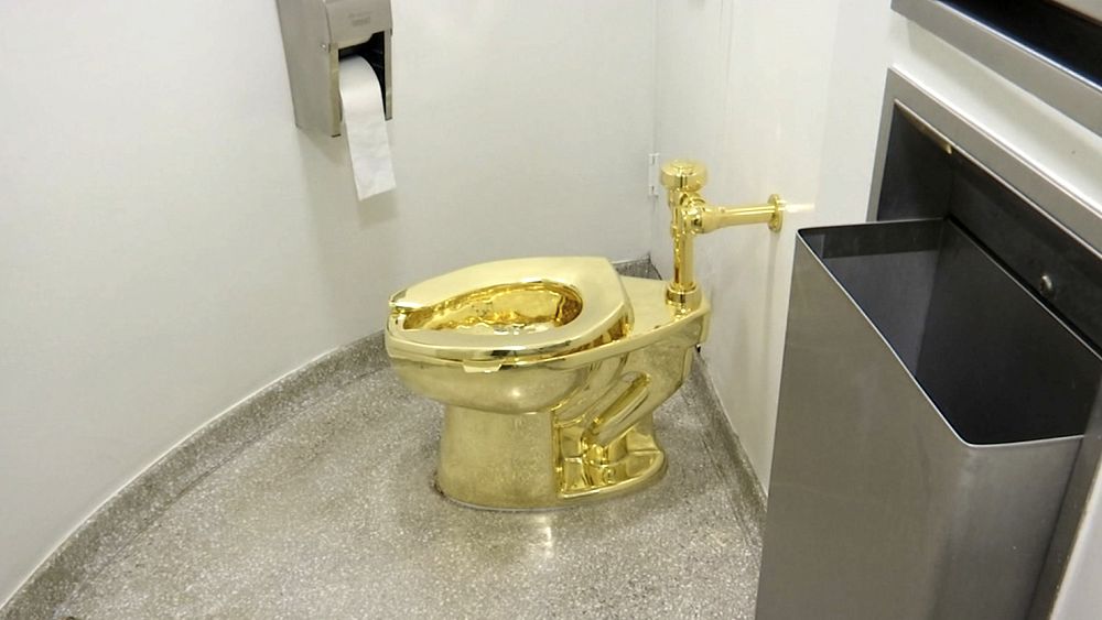 18 каратовата тоалетна озаглавена Америка от Маурицио Кателан в тоалетната на