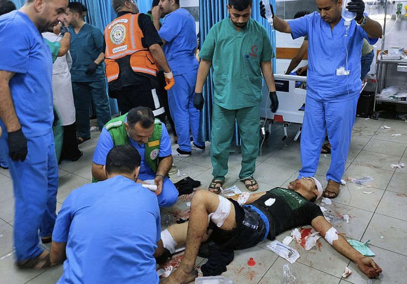 Az egyik gázai kórház padlózatán látnak el egy súlyos sérültet