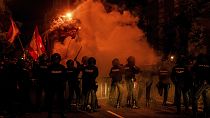 Police charge against far-right protesters as smoke flares are set off outside the Spanish Socialist party headquarters in Madrid, Spain, Monday Nov. 6, 2023. 