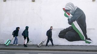 Emberek sétálnak Emmalene Blake művész palesztinbarát falfestménye mellett Dublin Harold's Cross negyedében, Írországban.