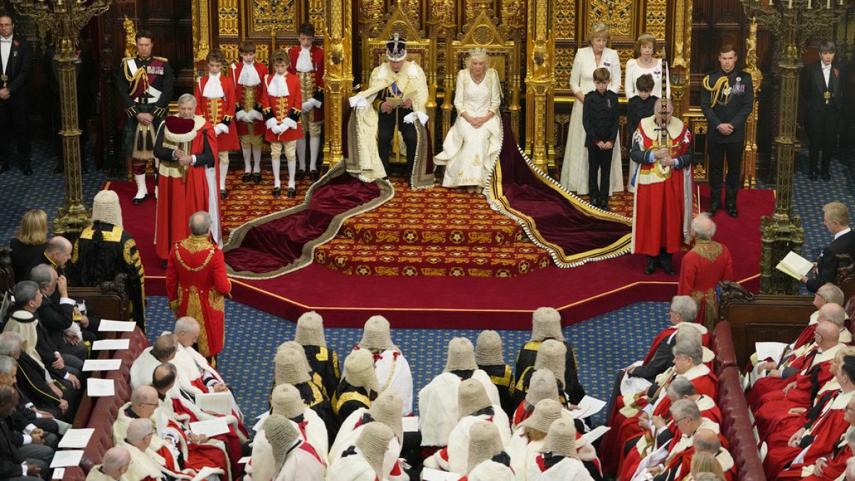 Mit der schweren Staatskrone auf dem Haupt trägt König Charles die Pläne seiner Regierung vor.