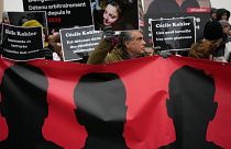 مردی با پرتره‌ای از سیسیل کوهلر در جریان اعتراضات در پاریس، ۲۸ ژانویه ۲۰۲۳