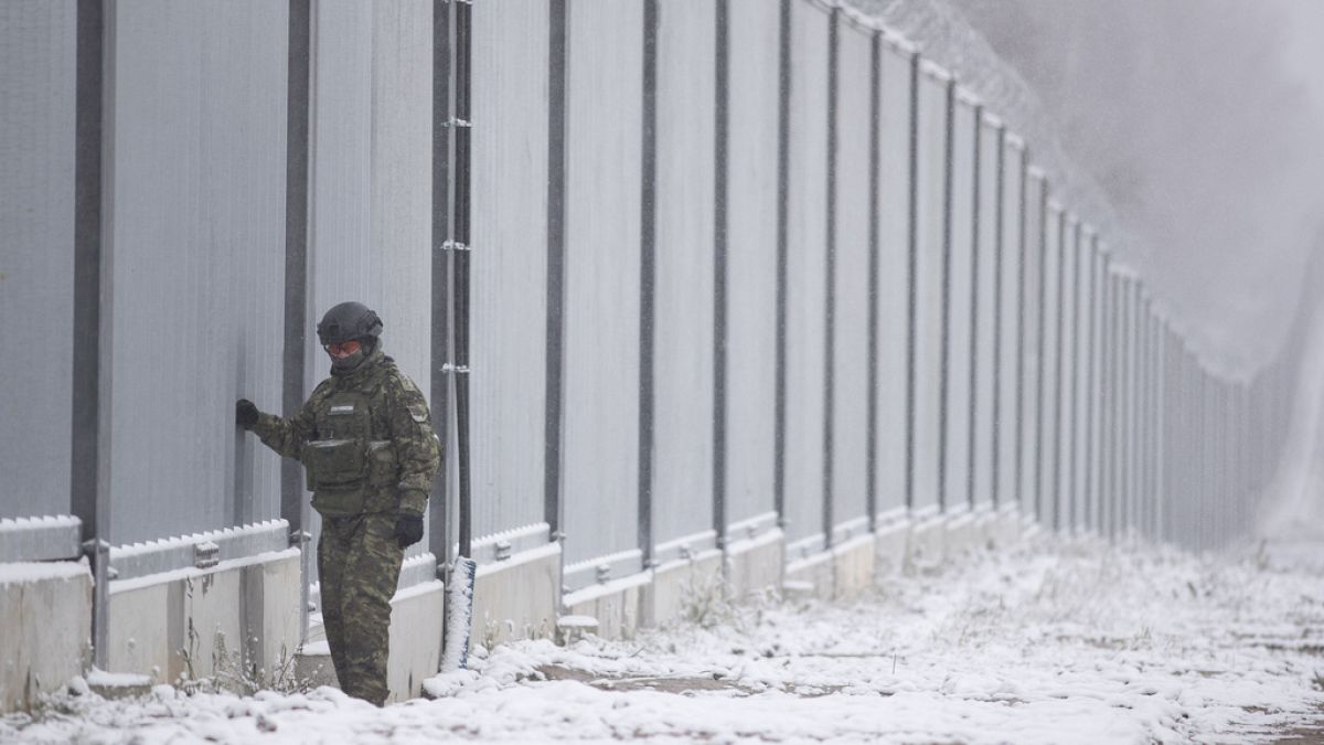DOSSIER - Un garde-frontière polonais se tient à côté du mur frontalier à Nomiki, en Pologne, le novembre 2022\. 