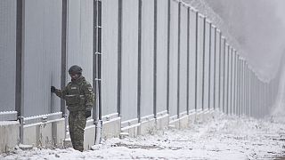 ARCHIVO - Un guardia fronterizo polaco junto al muro fronterizo en Nomiki, Polonia, en noviembre de 2022\. 