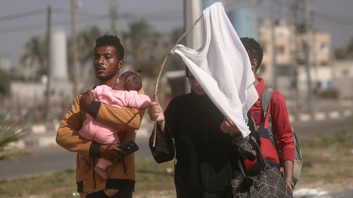 فلسطينيون يحملون راية بيضاء، ينزحون مشيا على الأقدام من مدينة غزة باتجاه الجنوب هربا من القصف الإسرائيلي