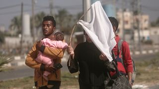 فلسطينيون يحملون راية بيضاء، ينزحون مشيا على الأقدام من مدينة غزة باتجاه الجنوب هربا من القصف الإسرائيلي