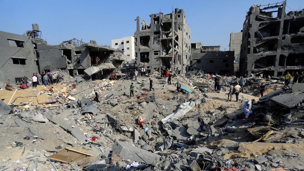 Палестинци се скитат сред отломките на сгради които бяха насочени