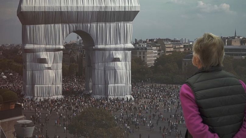 Wolfgang Volz, Christo and Jeanne-Claude’s Photographer admires a picture of the 50-metre-high Arc de Triomphe in Paris when it was wrapped in 2021