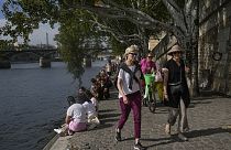 FILE - People walk along the Seine River, Oct. 2, 2023, in Paris where temperatures rose. 