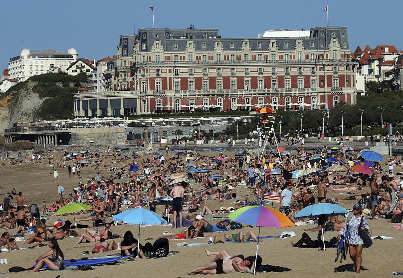 أشخاص يأخذون حمام شمس على شاطئ بياريتزفي جنوب غرب فرنسا،